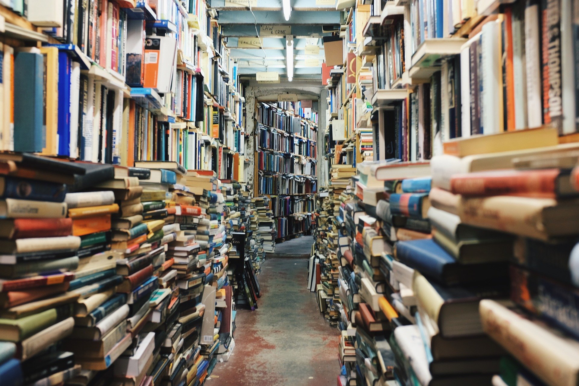 Gang in einem Buchladen: Die Bücher stapeln sich chaotisch bis zur Decke